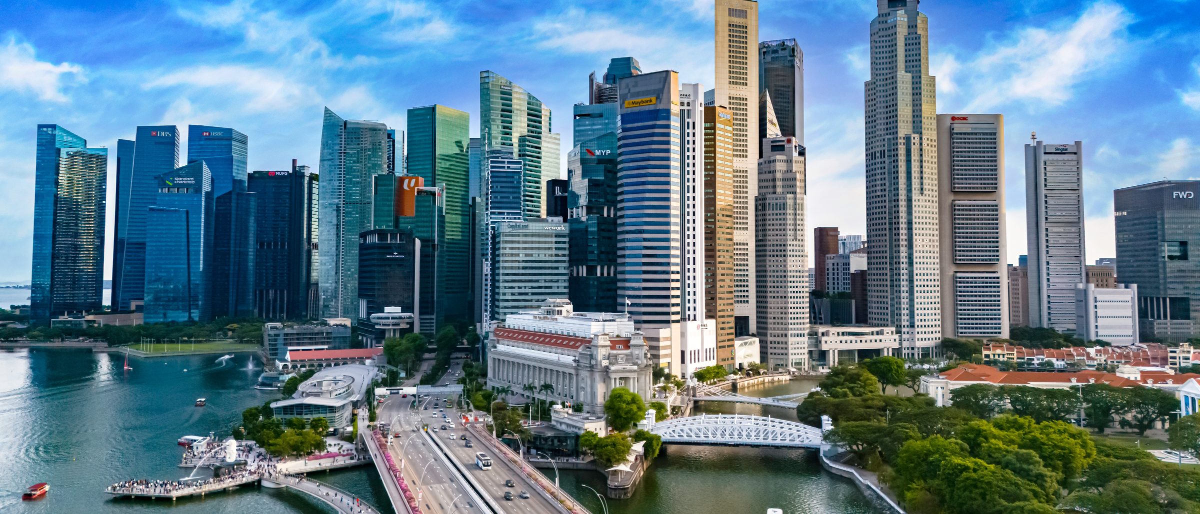 The Singapore central business district and the Fullerton building on the Singapore River in daylight