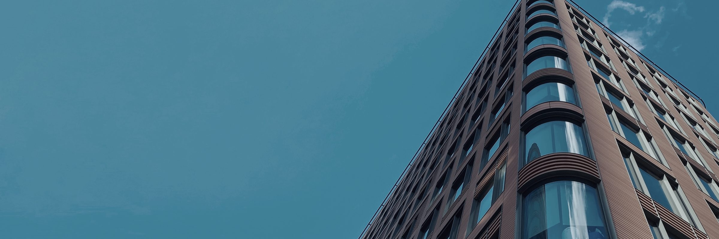 The corner of a commercial building seen from below, two facades meeting at a single vertical line