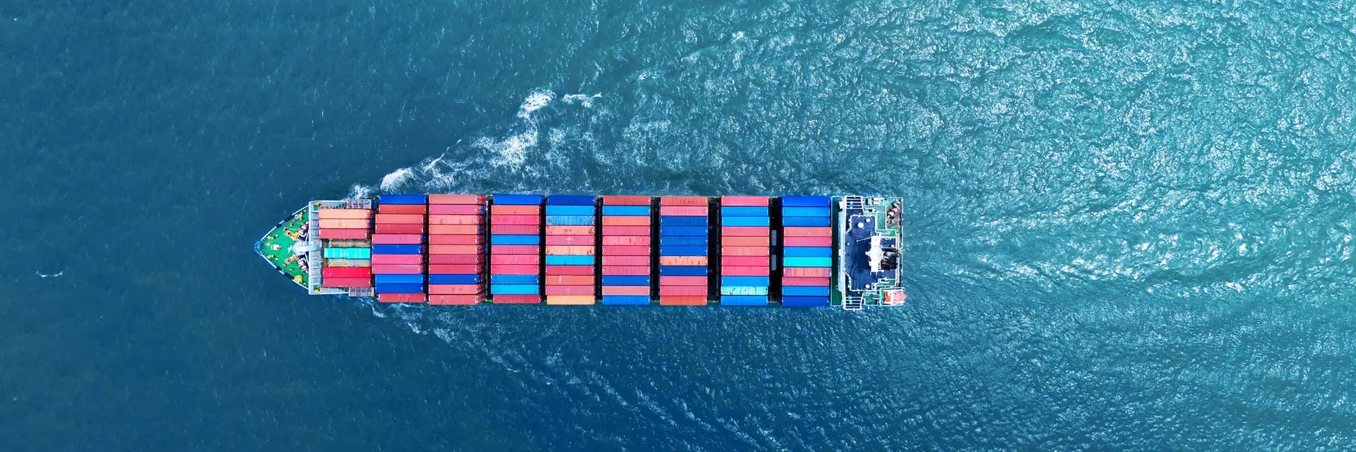 A loaded container ship under way, photographed from directly above on open water